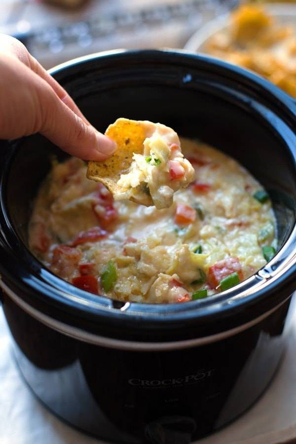 Crab and Artichoke Dip in a small slow cooker and on a chip.