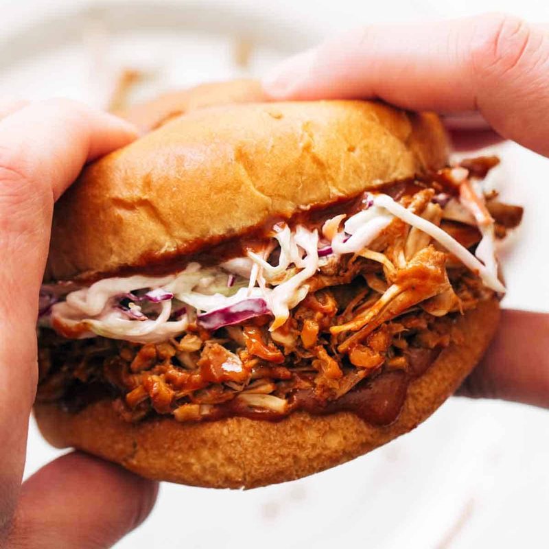 A person holding a jackfruit sandwich.