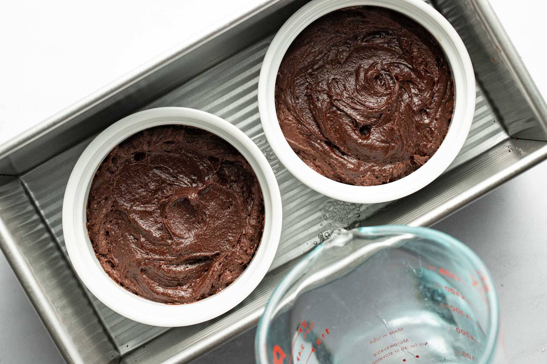 Adding brownie pudding batter to two ramekins.
